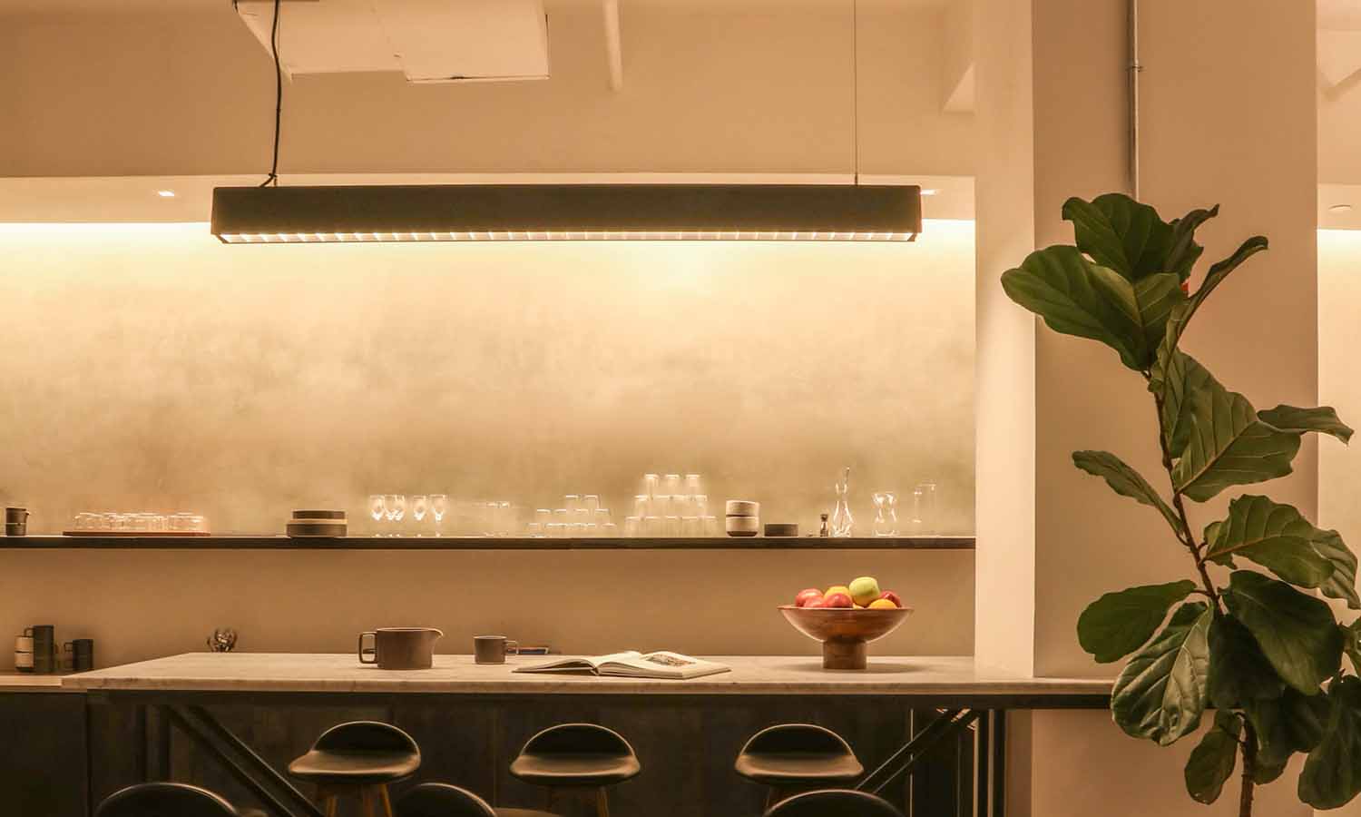 Bright kitchen with pendant lights and undercabinet lighting highlighting marble backsplash