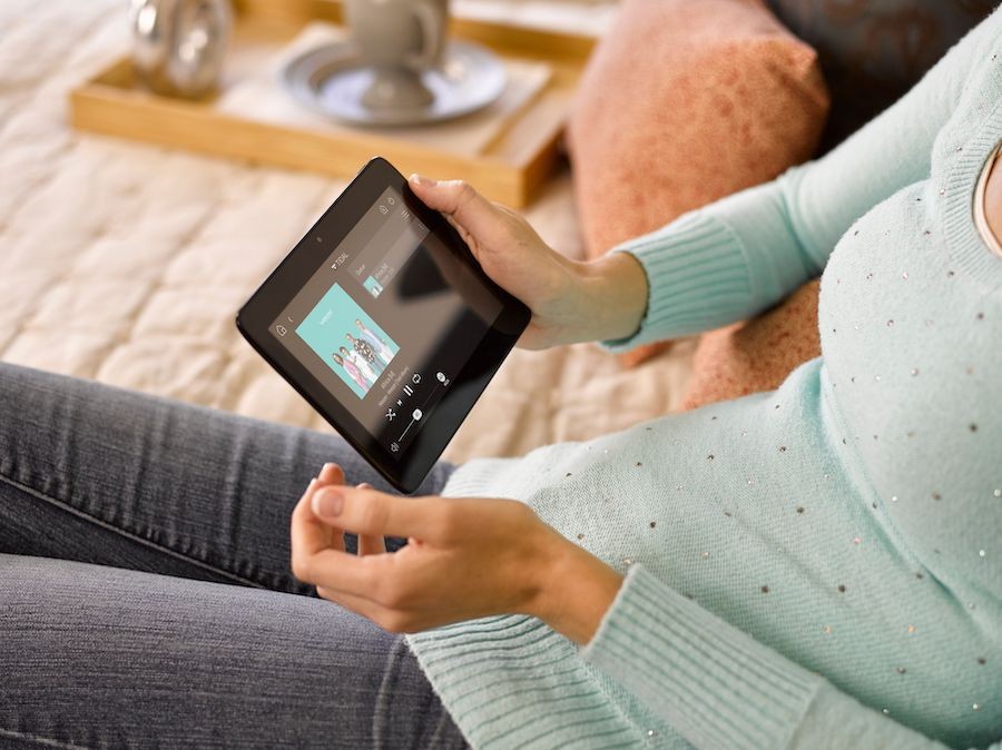 A woman holding her Control4 touchscreen device.