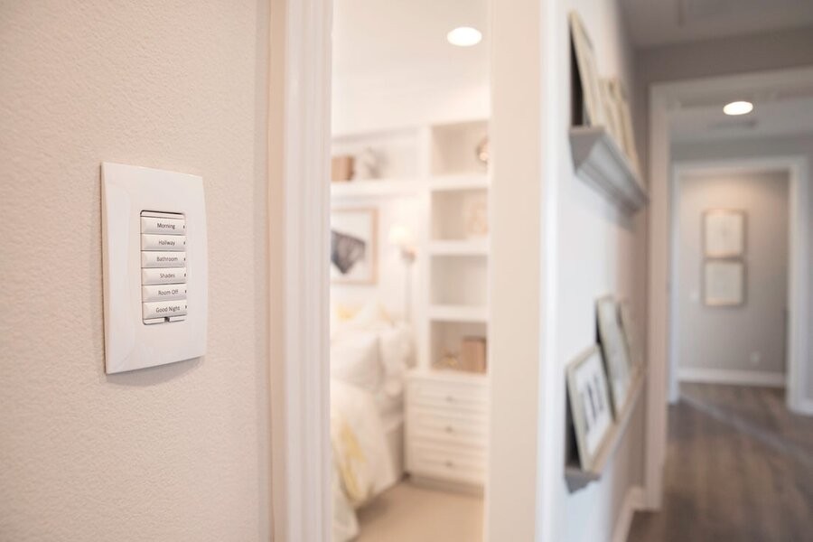 A hallway illuminated by Control4 lighting fixtures with a Control4 keypad interface on the wall in focus.