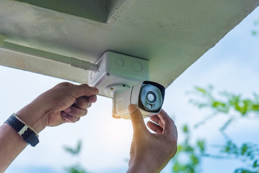 An outdoor security camera being installed on outdoor roofing.