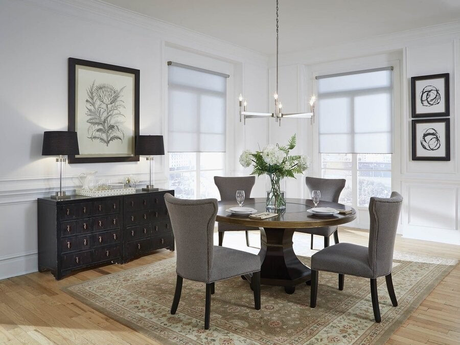 A dining area setup featuring lighting fixtures and motorized shading from Lutron smart lighting system.