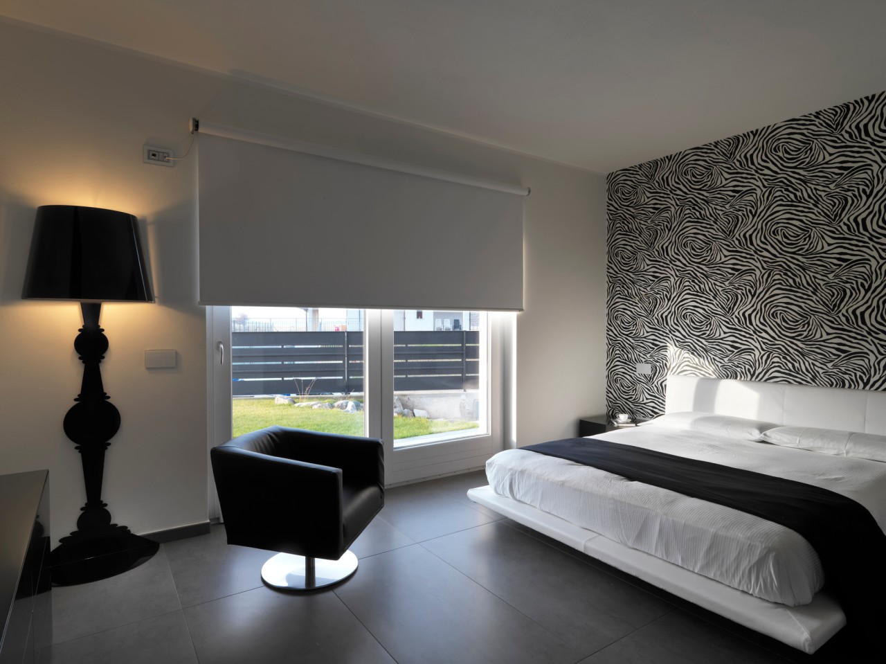 modern bedroom with leather armchair and black wall lamp